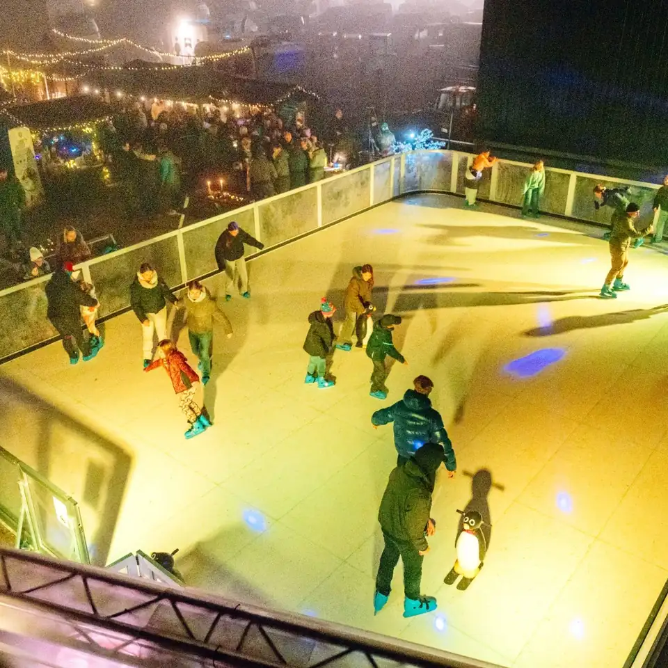 Besucherinnen und Besucher auf der Eisbahn, von oben fotografiert