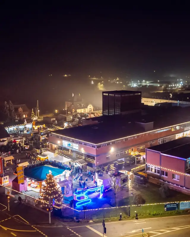 Der beleuchtete Weihnachtsmarkt zwischen den Hallen, von oben fotografiert