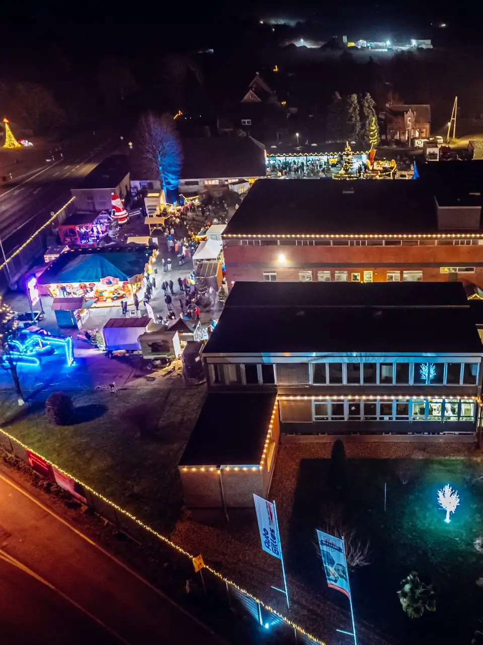 Das Firmengelände bei Nacht von oben, Stände und Lichter zwischen den Gebäuden